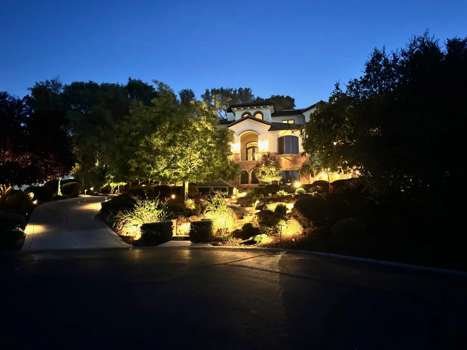 Estate driveway and gardens lit at dusk