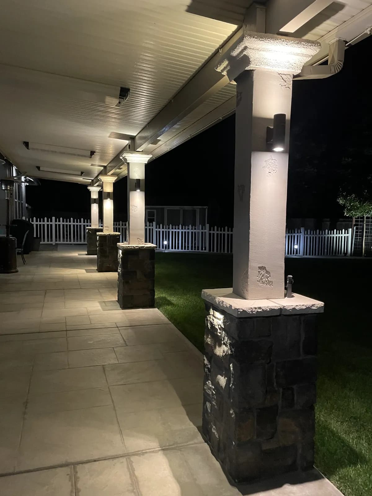 Stone patio columns with down lighting at night