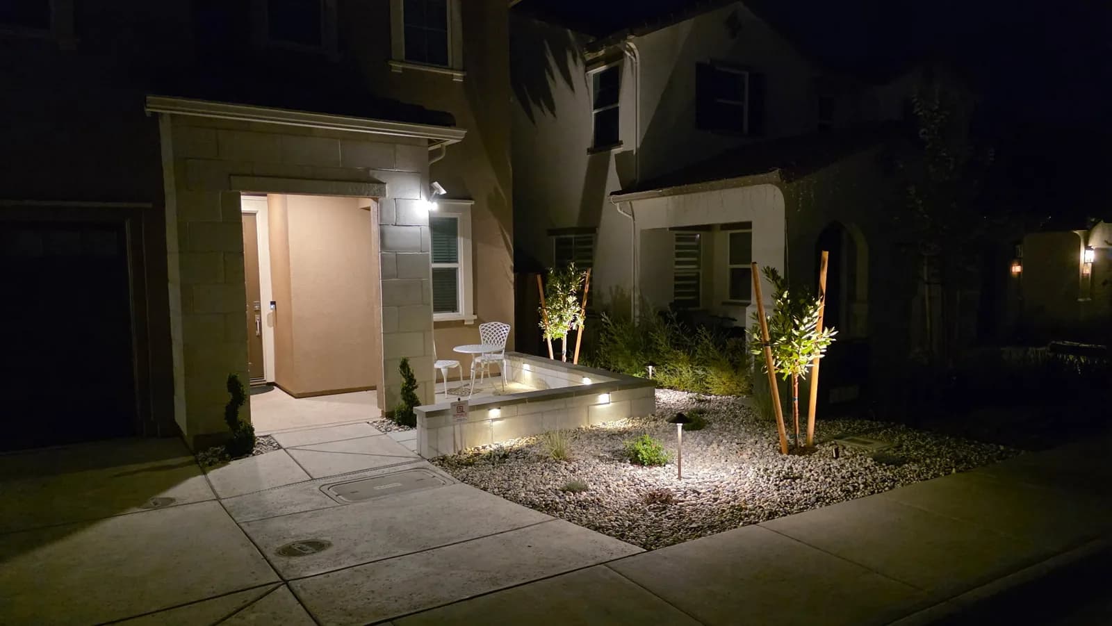 Home courtyard with lit planters and patio