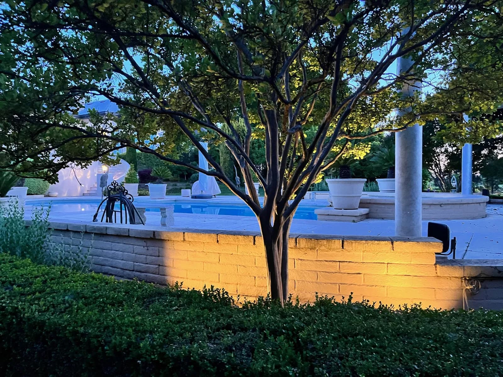 Pool and garden wall lit at blue hour