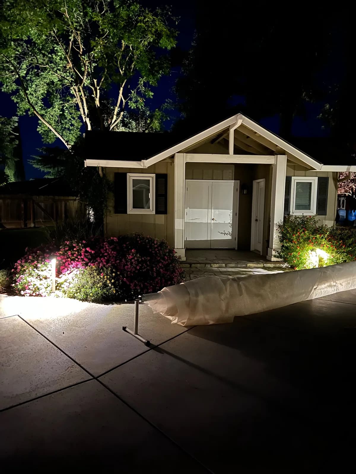 Backyard cottage with lit flower beds