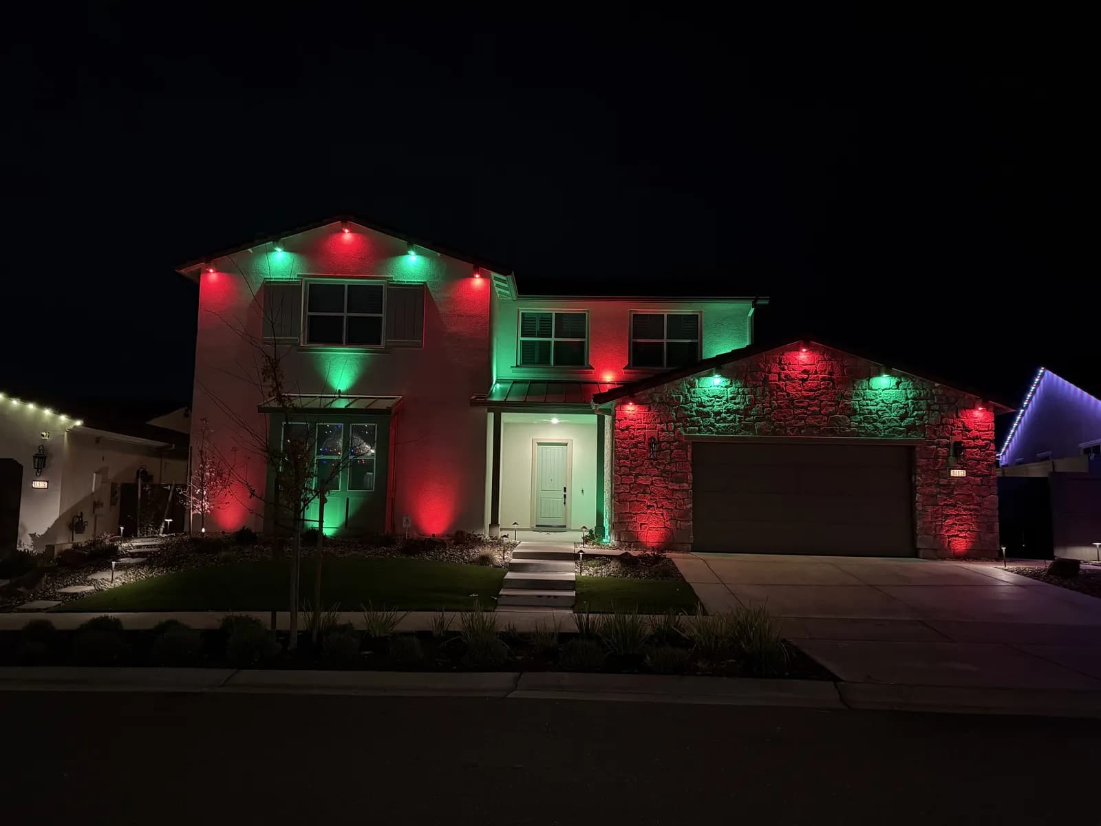 Two story home lit red and green