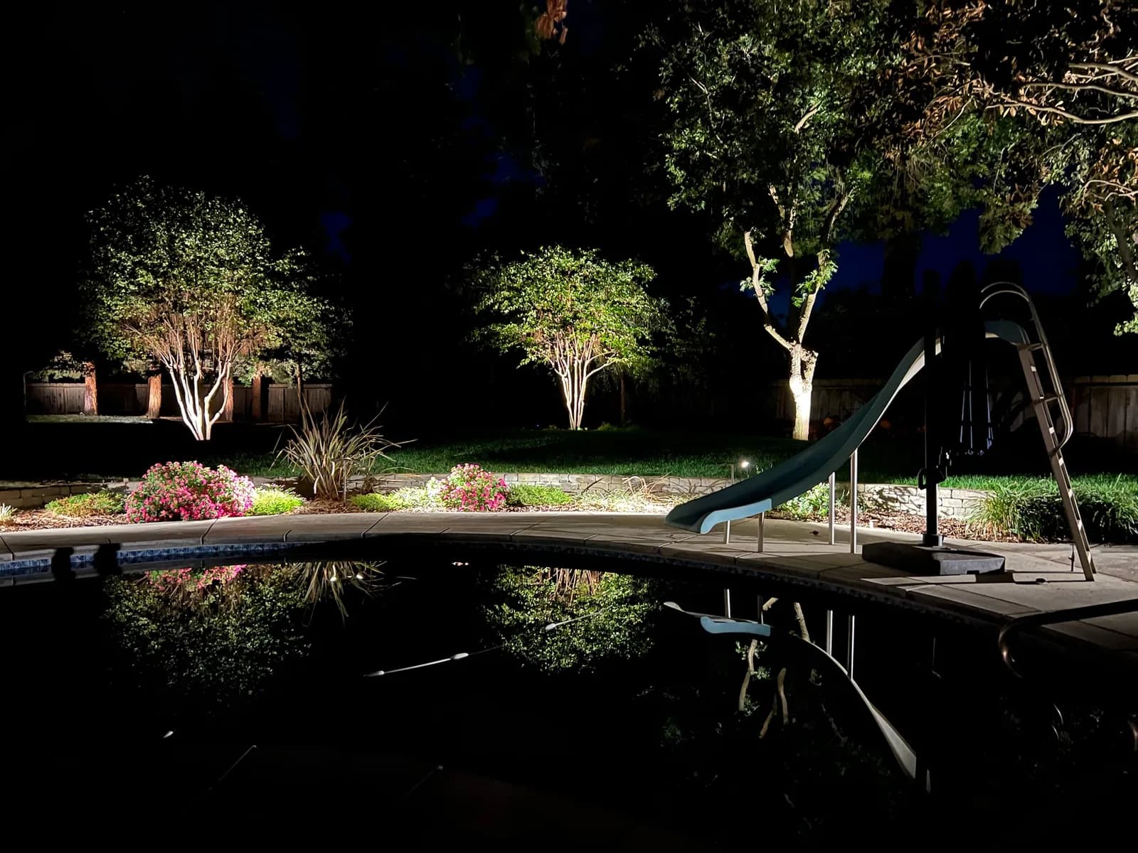 Pool yard with uplit trees